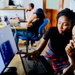 Customer service agent monitoring an AI chatbot conversation on a laptop