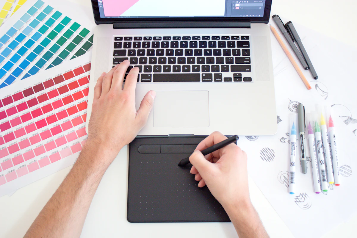 Graphic designer working on a laptop with colour swatches for a small business project
