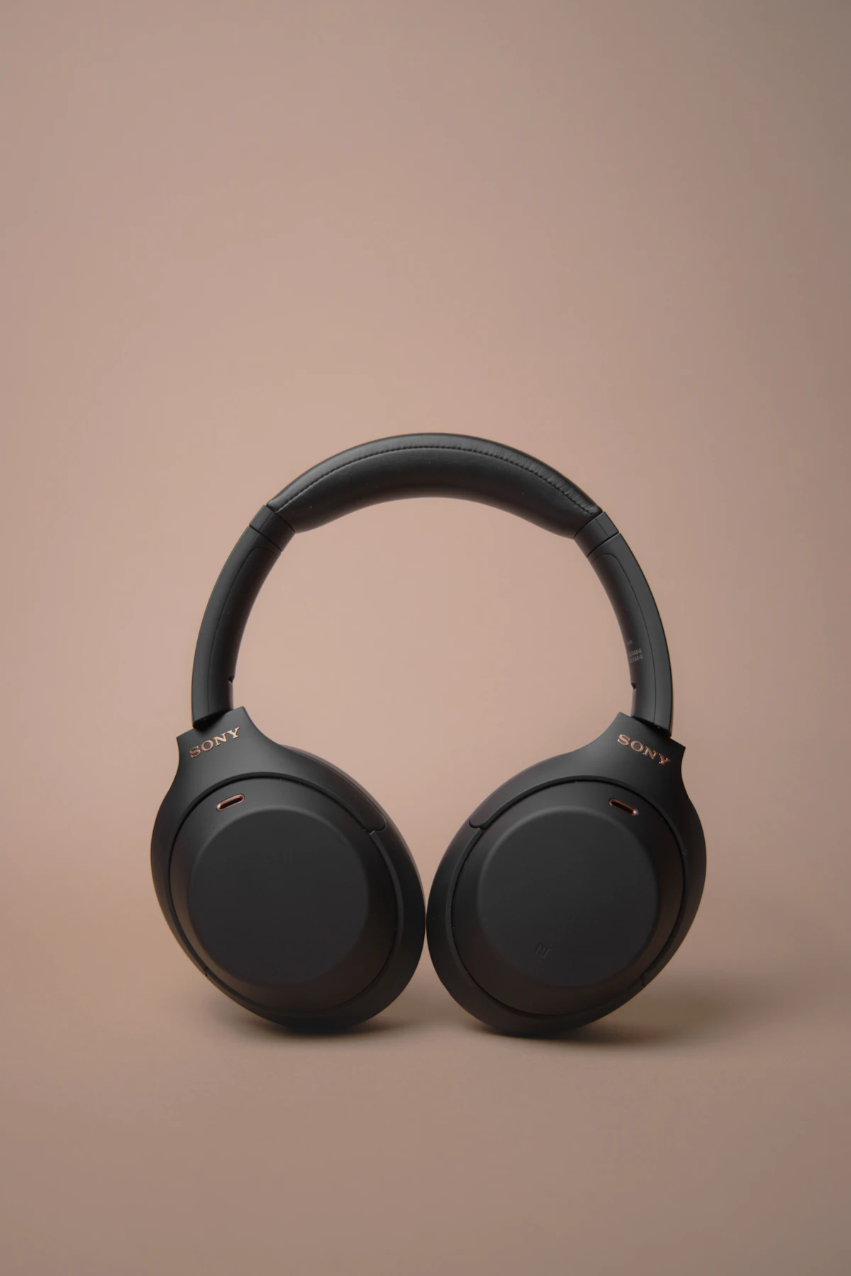 Person wearing noise-cancelling headphones while working remotely on a laptop